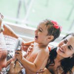Родители с ребенком весело играют в ванной в бунгало Доминиканы