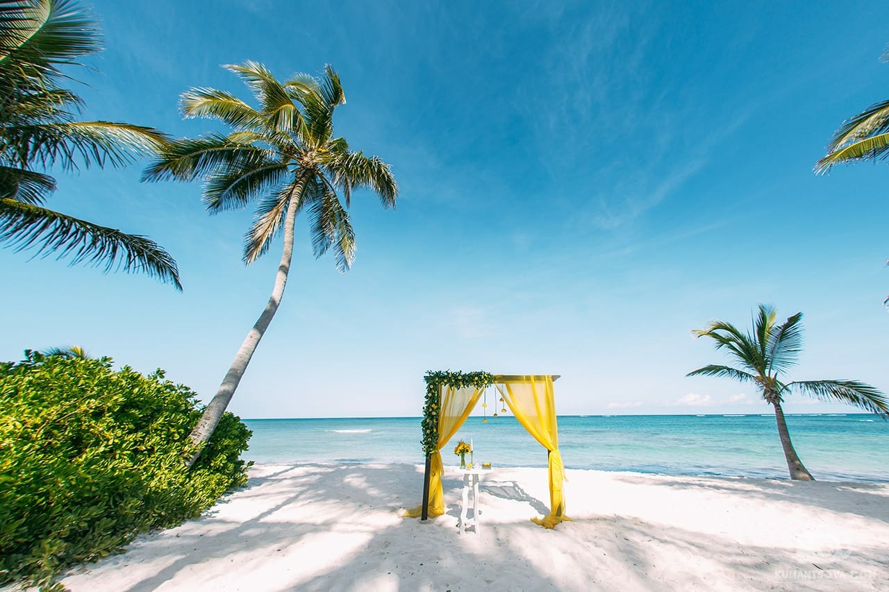 желтая свадебная арка на пляже в Доминикане